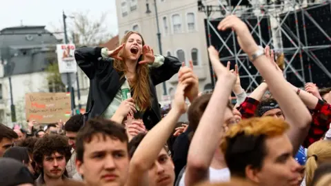 Reuters A woman on someone's shoulders during a protest