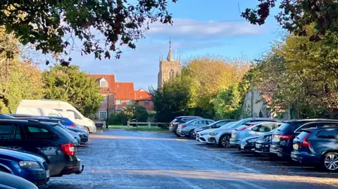 Cars are parked in bays on either side of Butts Land car park in Aylsham. 