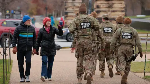 A woman waved to soldiers in camouflage in Washington DC in December