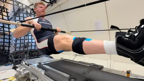 Matthew Wells, olympic medalist, floats as he rows on a parabolic flight. 