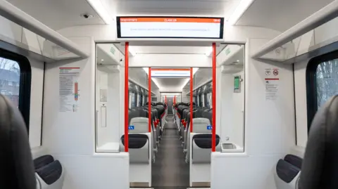 Transport for Wales The interior of a South Wales Metro tram train with seats and display screens