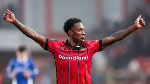 Liam Gordon playing for Walsall with his arms outstretched