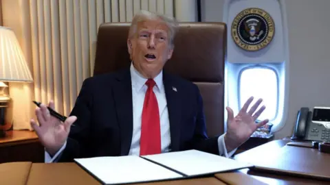 Reuters US President Donald Trump speaks to reporters aboard Air Force One (9 February 2025)