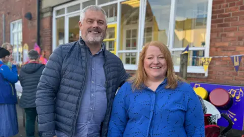 Michael and Naomi Long, both in blue shirts and a blue jacket on Michael pictured at primary school event