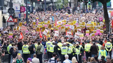 PA Media Counter-protesters and police gather ahead of an anti-immigration protest