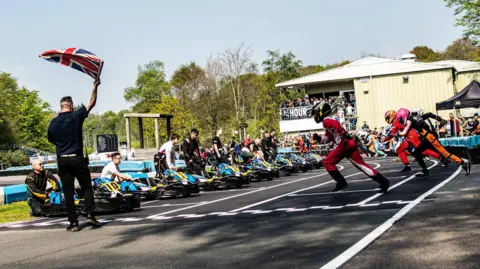 24 hour karting race competitors and pit crews prepare for an event on the track at Buckmore Park in Chatham