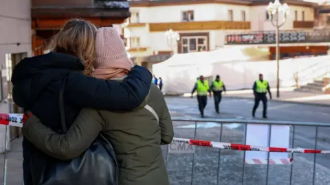 Police officers inspect the area where a fire broke out at the Le Constellation bar and lounge following an explosion in the early hours of New Year's Eve, in Crans-Montana, Switzerland. A police tape cordon is in front of the premises