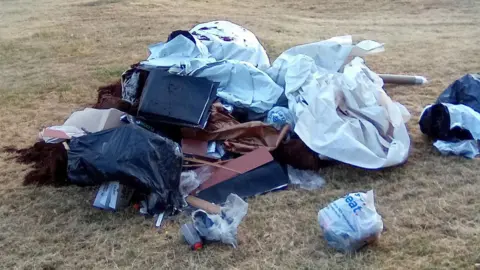 A pile of rubbish strewn on grass