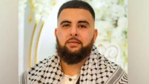 A family photograph of Raad Asmael with a beard and wearing a scarf