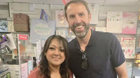 Moortown Post Office Post office worker Meshie smiles next to former England manager Sir Gareth Southgate.