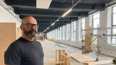 Museum director Joe Brook standing in the new space