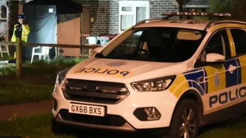 EDDIE MITCHELL A police car parked outside a crime scene in Crawley.