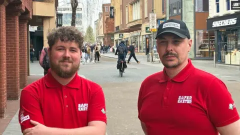 Community safety officers Jamie Woodward and Martin Jeffery wearing red polo shirts