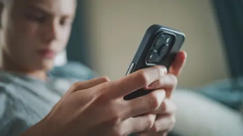 Getty Images Stock image of a boy looking at a phone