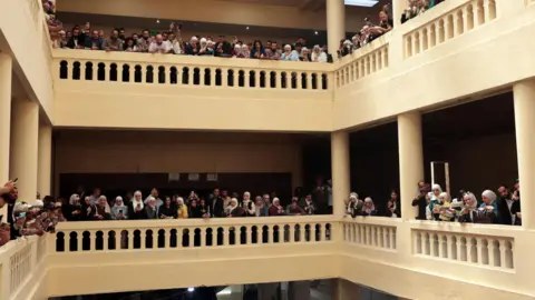 EPA Victims' families, journalists, activists and other people gather inside the Palace of Justice, on the opening day of the trial of Atef Najib, former head of Political Security in Deraa under ousted president Bashar al-Assad, in Damascus, Syria (26 April 2026)