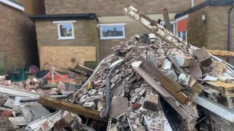 Simon Thake A mound of building rubbish piled up outside a house