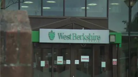 BBC The outside of West Berkshire Council building with green logo above the glass doors.