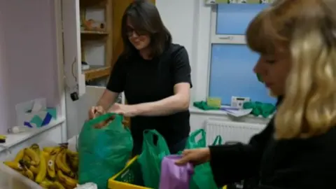 Two volunteers packing "harm-reduction packs" for sex workers