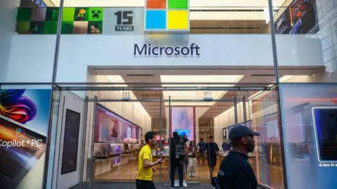 Getty Images People walk past a Microsoft store in New York