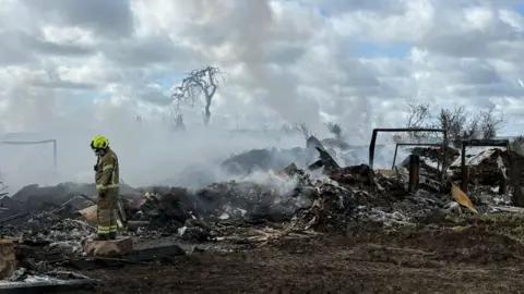 Nottinghamshire Fire and Rescue Service Nottinghamshire Fire and Rescue Service remain at the scene on Tuesday 21 April 2026 at Hathernware Industrial Estate, in Sutton Bonington, after a fire started on 15 April 2026.