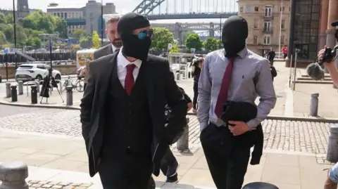 PA Media Daniel Graham (left) and Adam Carruthers leaving Newcastle Upon Tyne Magistrates' Court after appearing in connection with the felling of the Sycamore Gap tree