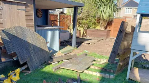 Dorset Council A garden with building materials scattered about in a messy fashion. 