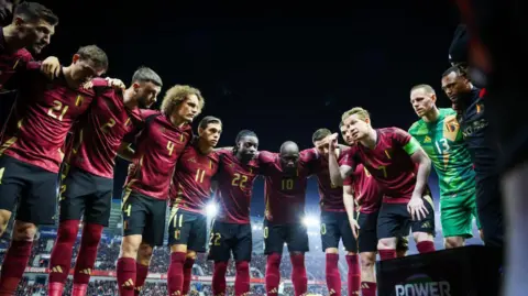 Kevin de Bruyne gives a team talk in a huddle of Belgium players