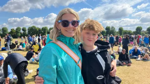 Emily Coady-Stemp/BBC A woman and a young boy embrace one another.