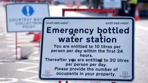 PA Media A sign that reads "emergency bottled water station" with further details of how much water visitors are entitled to collect. The sign features South East Water branding.