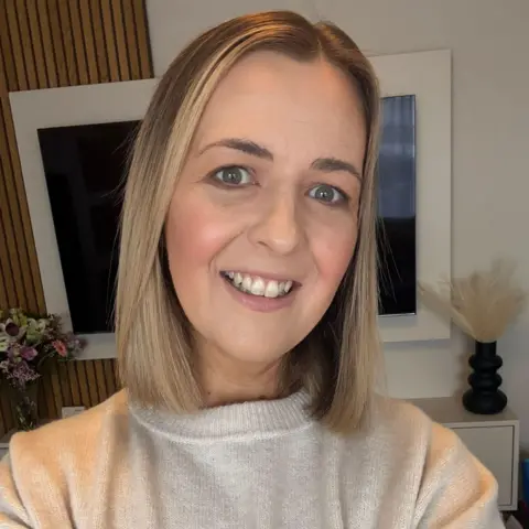 Cheryl Diamond Cheryl Diamond, who has blonde hair, smiles taking a selfie in her living room.