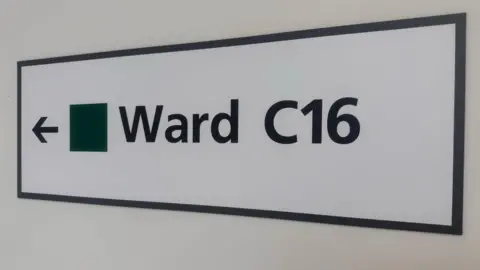 NWAFT A white rectangle sign with "Ward C16" written on it in black
