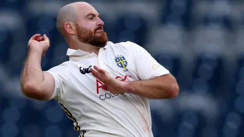 Ben Raine in bowling action for Durham with the ball in his right hand