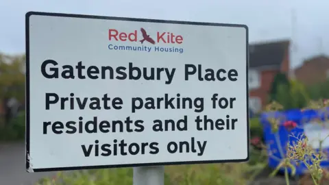 Local Democracy Reporting Service A Red Kite Community Housing sign, that says Gatensbury Place Private parking for residents and their visitors only