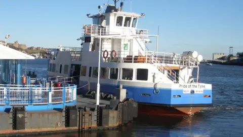 The Shields Ferry. The vessel has received new paint work. It is blue and white. The name Pride of the Tyne is printed on its stern.
