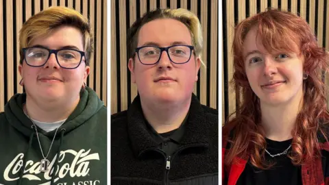 Ben Schofield/BBC A composite image of Kye Tilley, Cammy Findleton and Sam Dowling all looking down the camera. Kye is wearing a dark green hooded top with the Coca-Cola logo on the front and a silver chain around his neck. He is wearing rectangular-framed glasses with black rims. His hair is dark at the roots and dyed lighter at its tips and is swept to one side in a parting. Cammy is wearing a black zipped top over a black collared t-shirt. She is also wearing rectangular-framed glasses with black rims. Her hair is dark on the left as we look at her, with a sweep of blonde hair brushed over to the right. Sam Dowling has shoulder length, red hair. They are wearing a red and black open shirt, with a black t-shirt underneath and a silver chain around their neck. All three are standing in front of the same backdrop, which has vertical wooden slats running from the bottom of the images to the top.