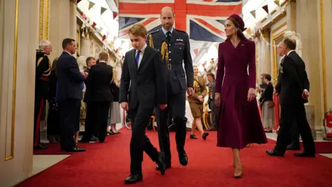 Reuters Prince George walks out of a room in Buckingham Palace followed by his mother and father, the Prince and Princess of Wales