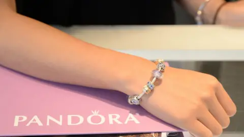 Getty Images A woman's hand wearing a Pandora charm bracelet.