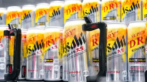 Toru Hanai/Bloomberg via Getty Images Cans of Asahi Dry. The cans are silver and yellow.