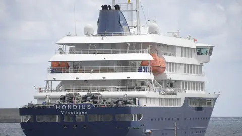 Large blue and white cruise ship with the words Hondius Vlissingen on it 