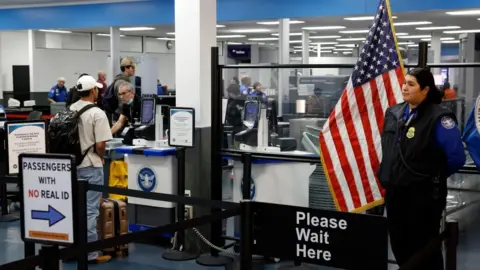A Transportation Security Administration employee waits at a security checkpoint at the Hollywood Burbank Airport in Burbank, California