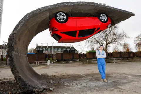 Getty Images Alex Chinneck pictured in 2015 with his art installation "Pick yourself up and pull yourself together"