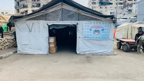 Media tent in Gaza, with other visible tents in the background.