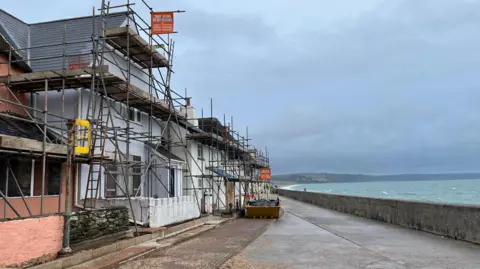 Scaffolding on houses along the seafront in Torcross. 