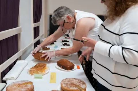 Jim Grover A judge handles one of the cakes on display