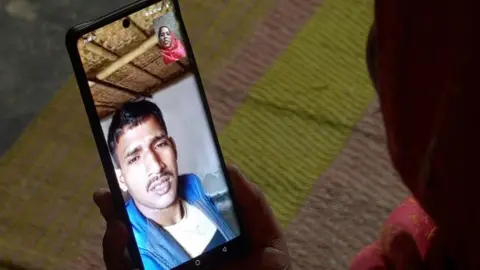 Rubaiyat Biswas/BBC Sunali is looking at her husband, Danish, as she speaks to him on a video call.