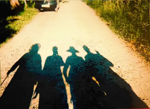 Deborah O’Donoghue  Shadows of four people on a path on the Camino de Santiago