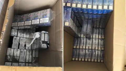 Trading Standards Shot of packets of cigarettes inside boxes. One box contains cigarettes in silver packets with the initials L&B displayed. The others are labelled Richmond.