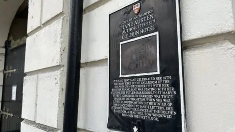 LDRS Black rectangular plaque with white writing mounted on ground floor of the Dolphin hotel