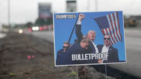 BBC A poster of Trump with blood on his face and fist raised, with words "BULLETPROOF"