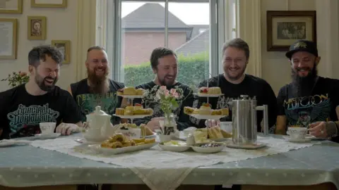 Supplied The band enjoy a joke while having afternoon tea